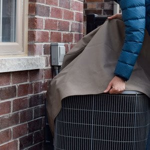 Should you cover your central air conditioner in the winter?