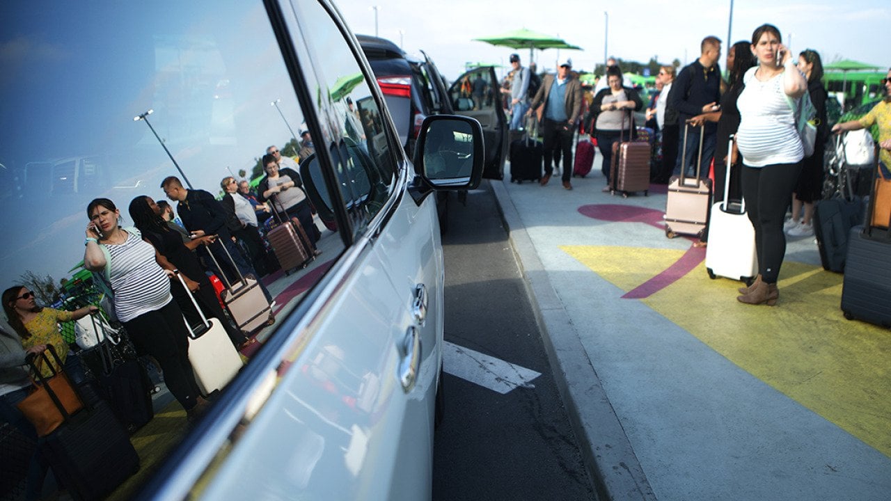 Arriving passengers wait to board Uber vehicles at the new 'LAX-it' ride-hail passenger pickup lot at Los Angeles International Airport (LAX) in California.