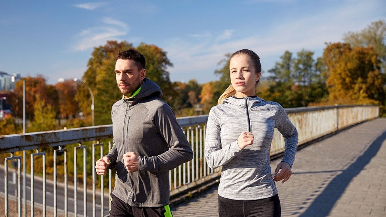 A couple running outdoors in the morning.