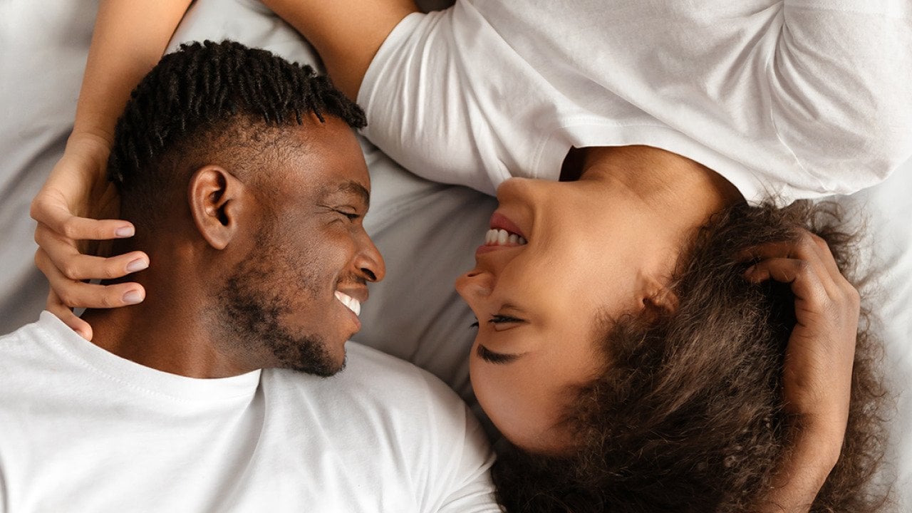 A black couple enjoying intimacy in bed.