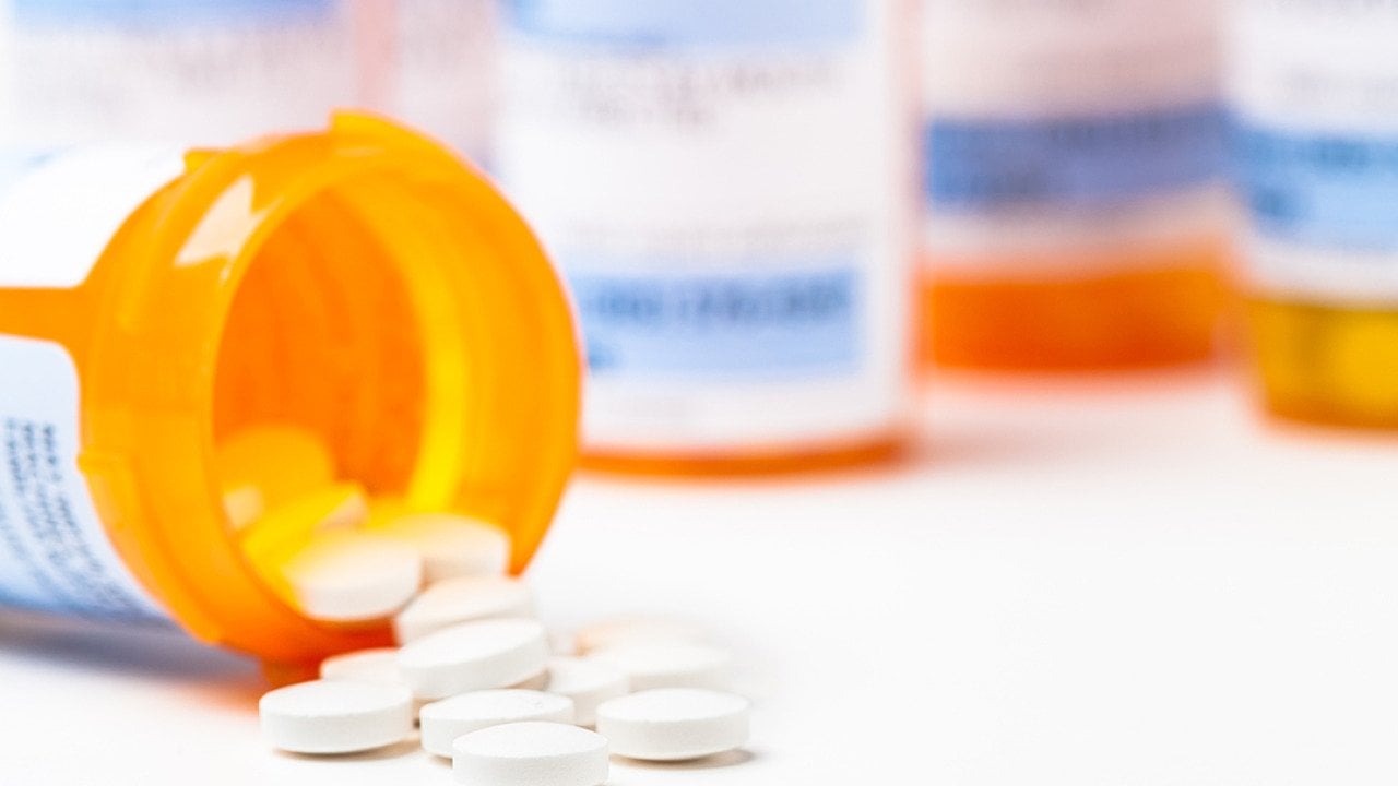 Prescription tablets spilling from bottle.