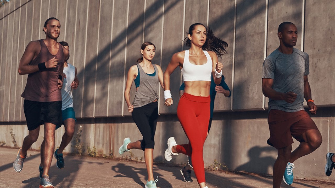 A group of people jogging outdoors.