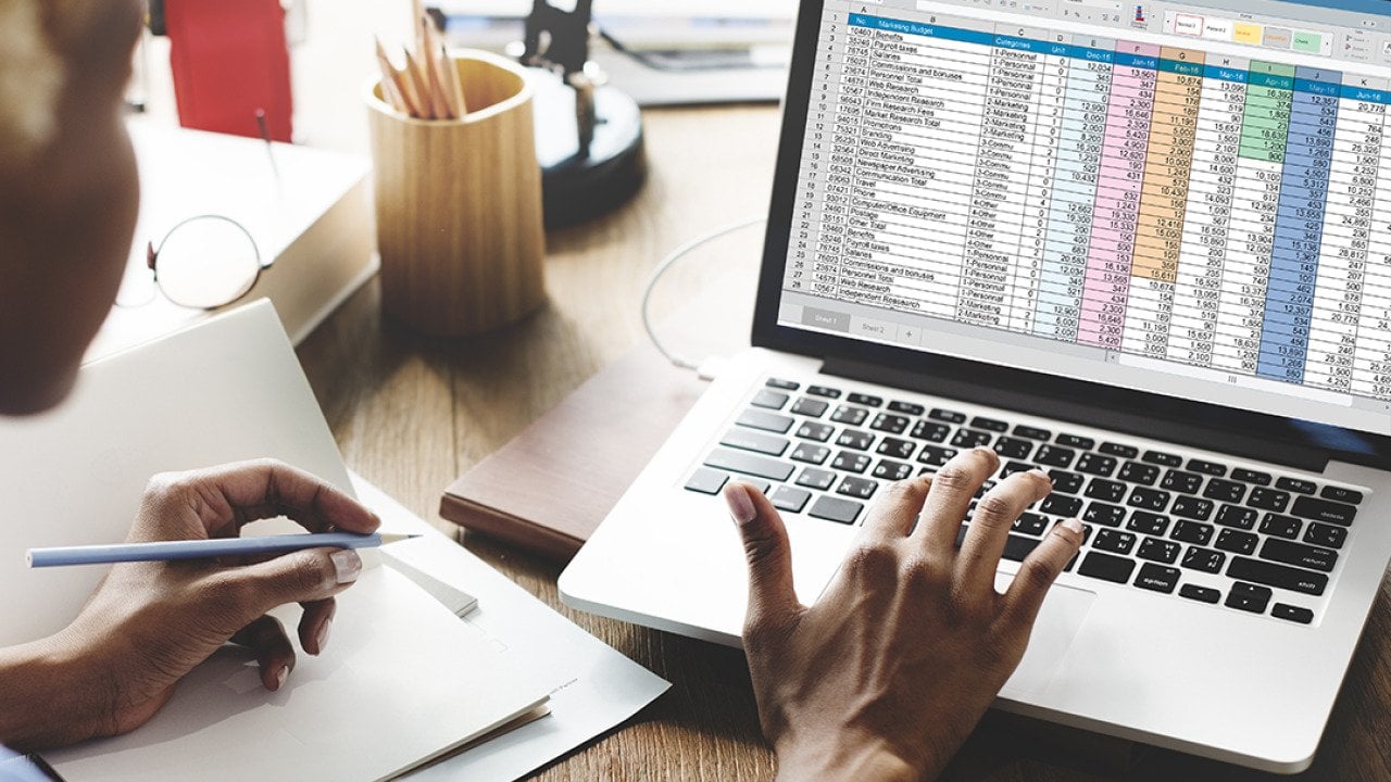 Young female entrepreneur looking at a spreadsheet report.