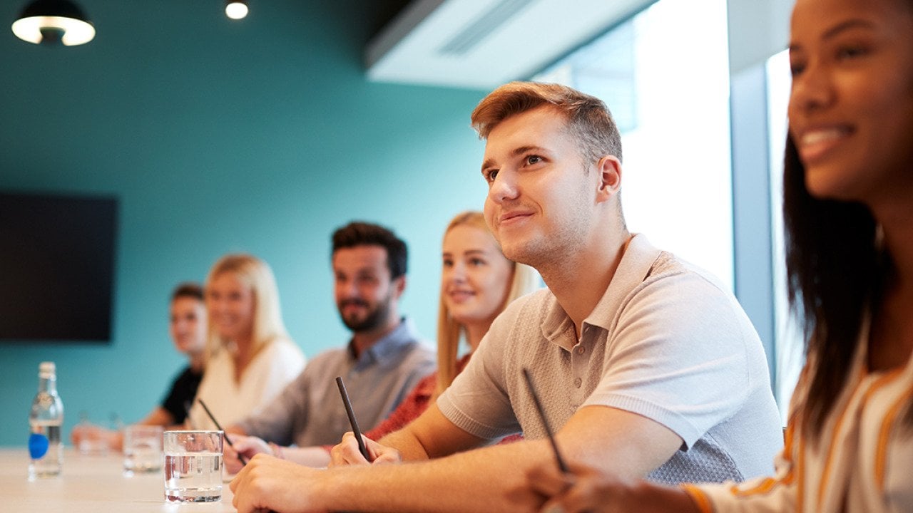 A group of post-graduate candidates in a boardroom.