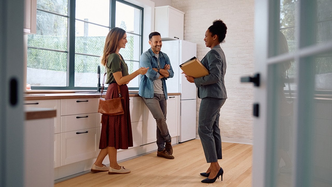 A couple talking with a real estate agent.