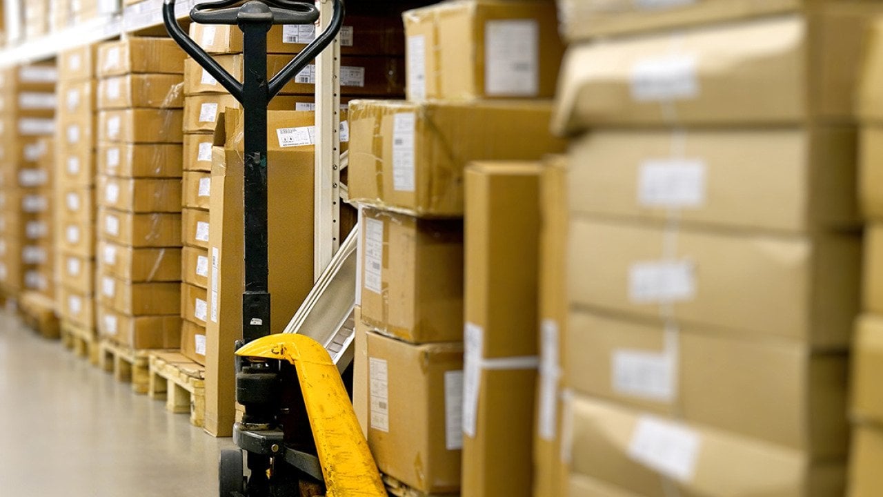 A manual pallet jack in a warehouse aisle.