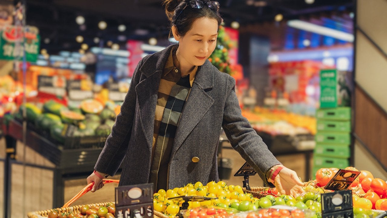 Young woman selecting fresh produce at the grocery store.