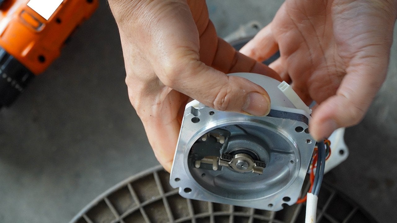 A mechanic repairing an AC servo motor.