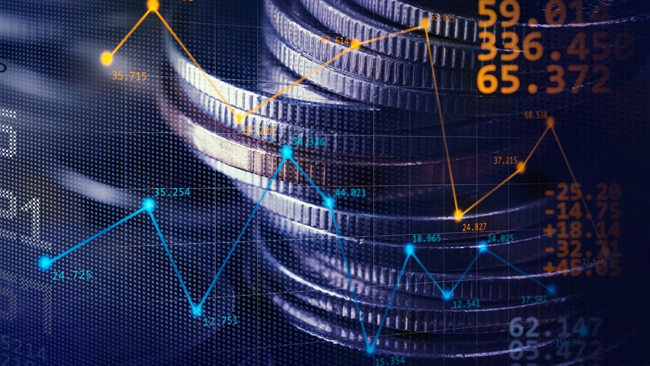 Stack of coins illustrated with stock exchange graphics.