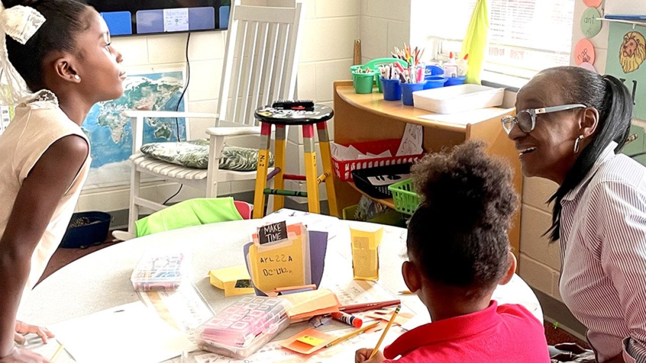 Volunteer Gae Bryant, right, works on a drawing exercise with two students in the K-2 class at The Ferguson School, a microschool that meets in an Atlanta-area church.