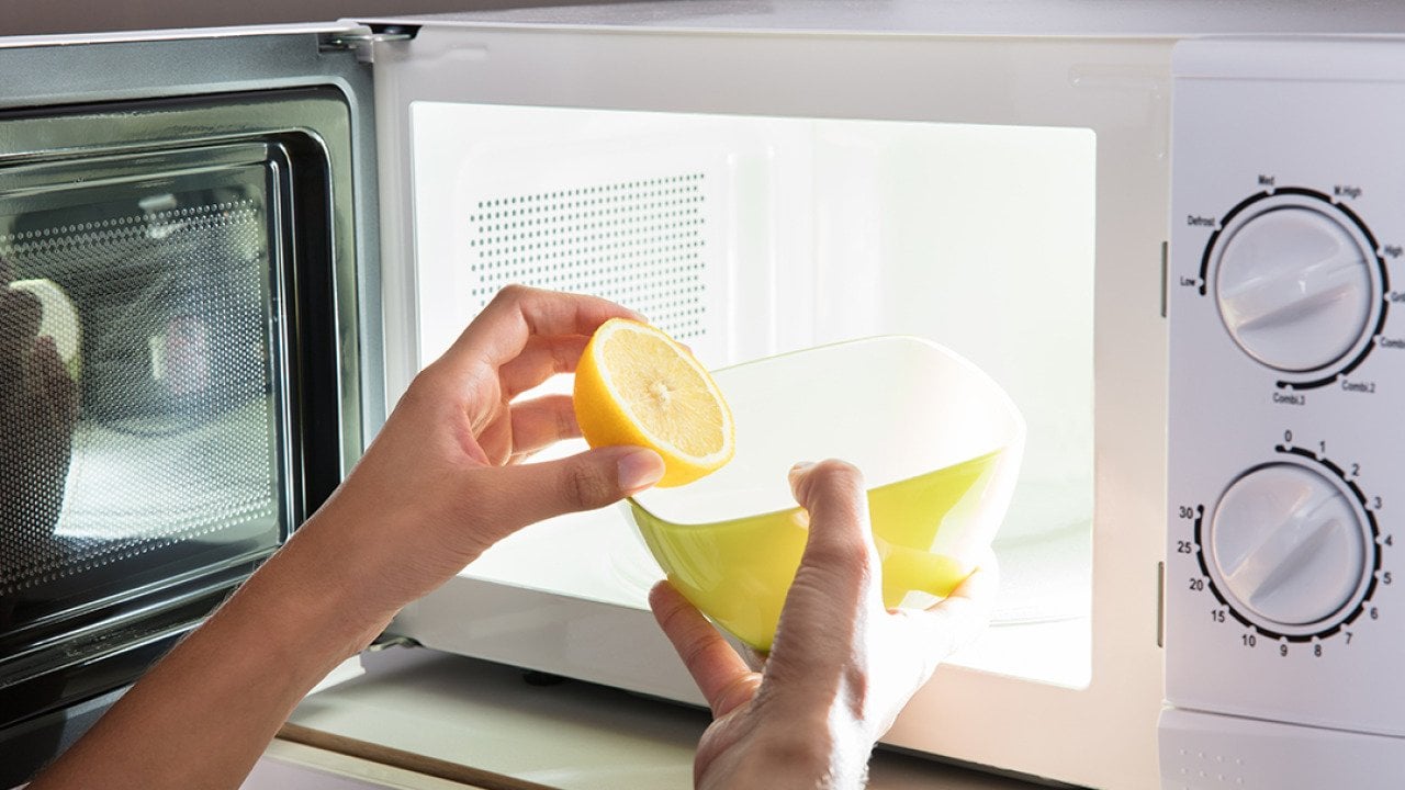 Microwave being cleaned with water and lemon.