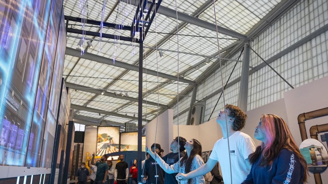 People interacting with a CityWorks exhibit exploring the water and wastewater infrastructure system.