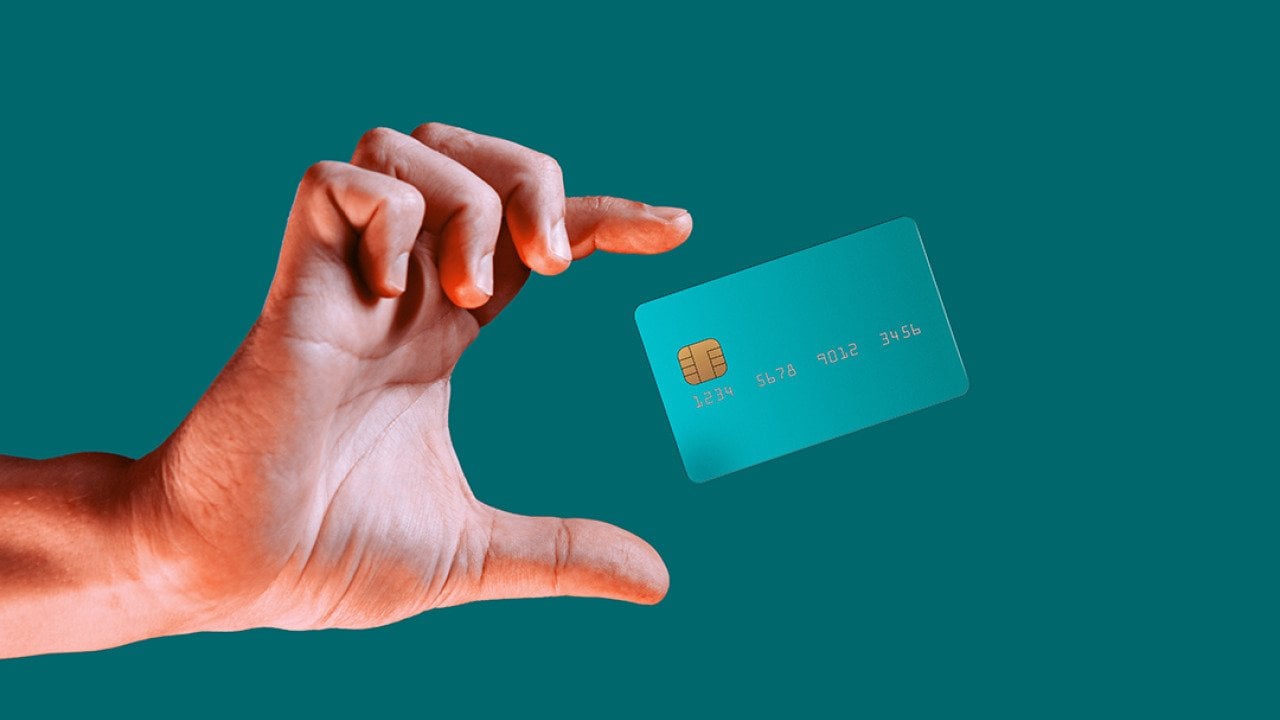 Hand reaching for a credit card mid-air.