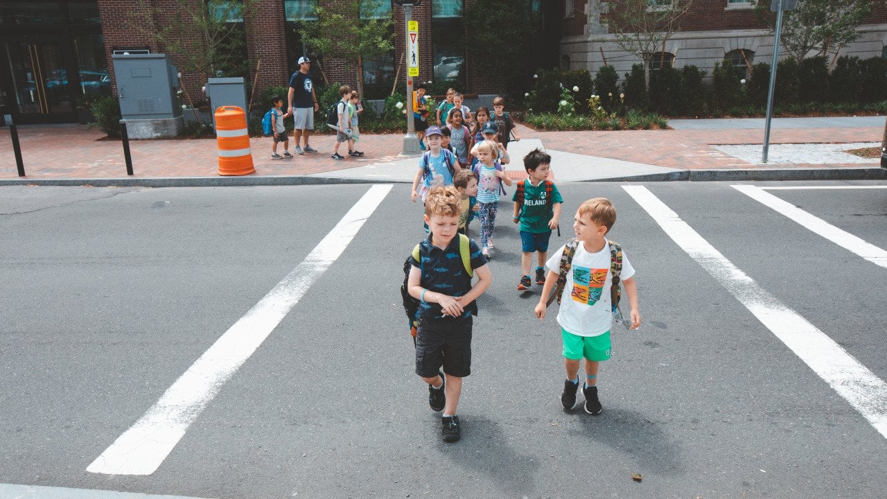 Kindergarten children group walking on crosswalk at Charles Street in Boston.