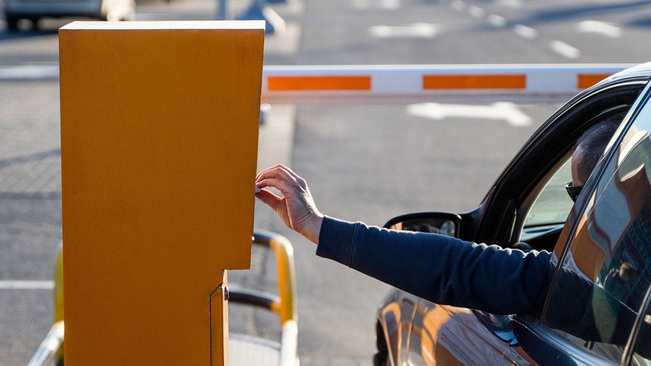 Person in the car paying for a parking ticket.