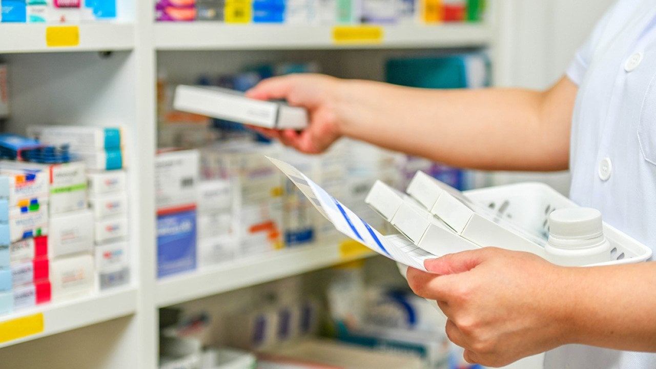A pharmacist filling prescription at a pharmacy.