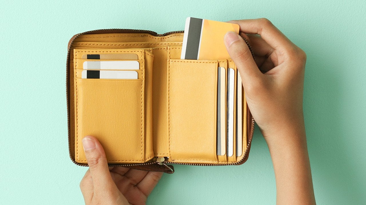 Person taking out a credit card from a wallet.