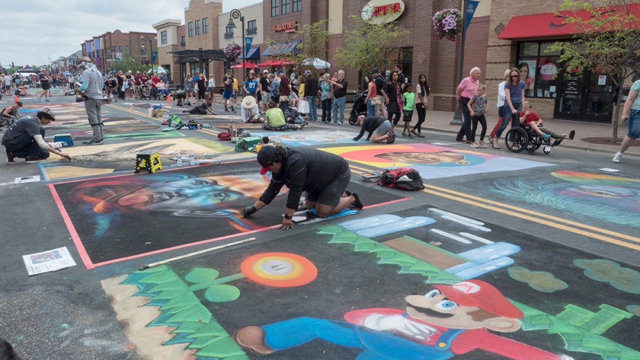 Chalk artists creating art during the Chalk Art Festival in Maple Grove, Minnesota.