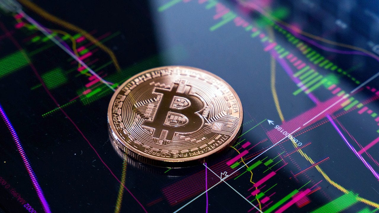 Gold bitcoin on top of finance graphic charts.