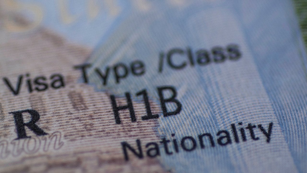 Stamp of an H1B worker's visa on a passport.