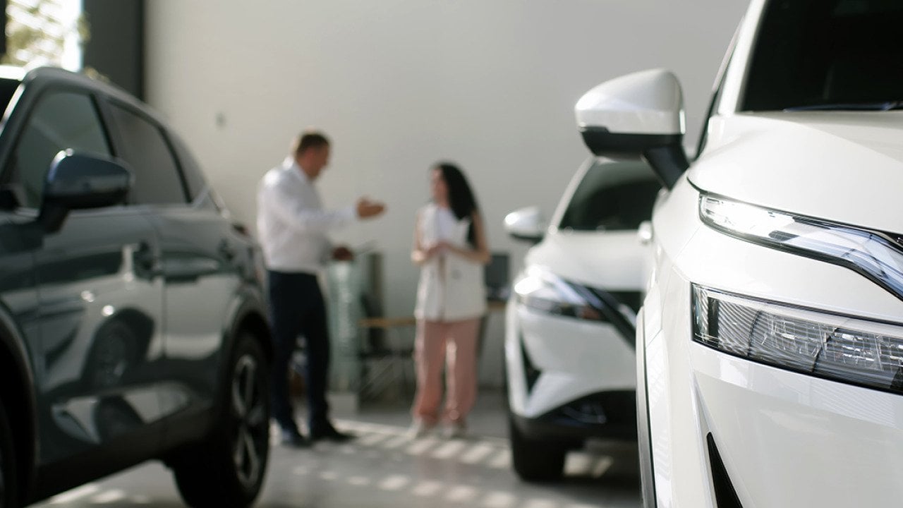 A manager and an interested buyer in a car dealership.