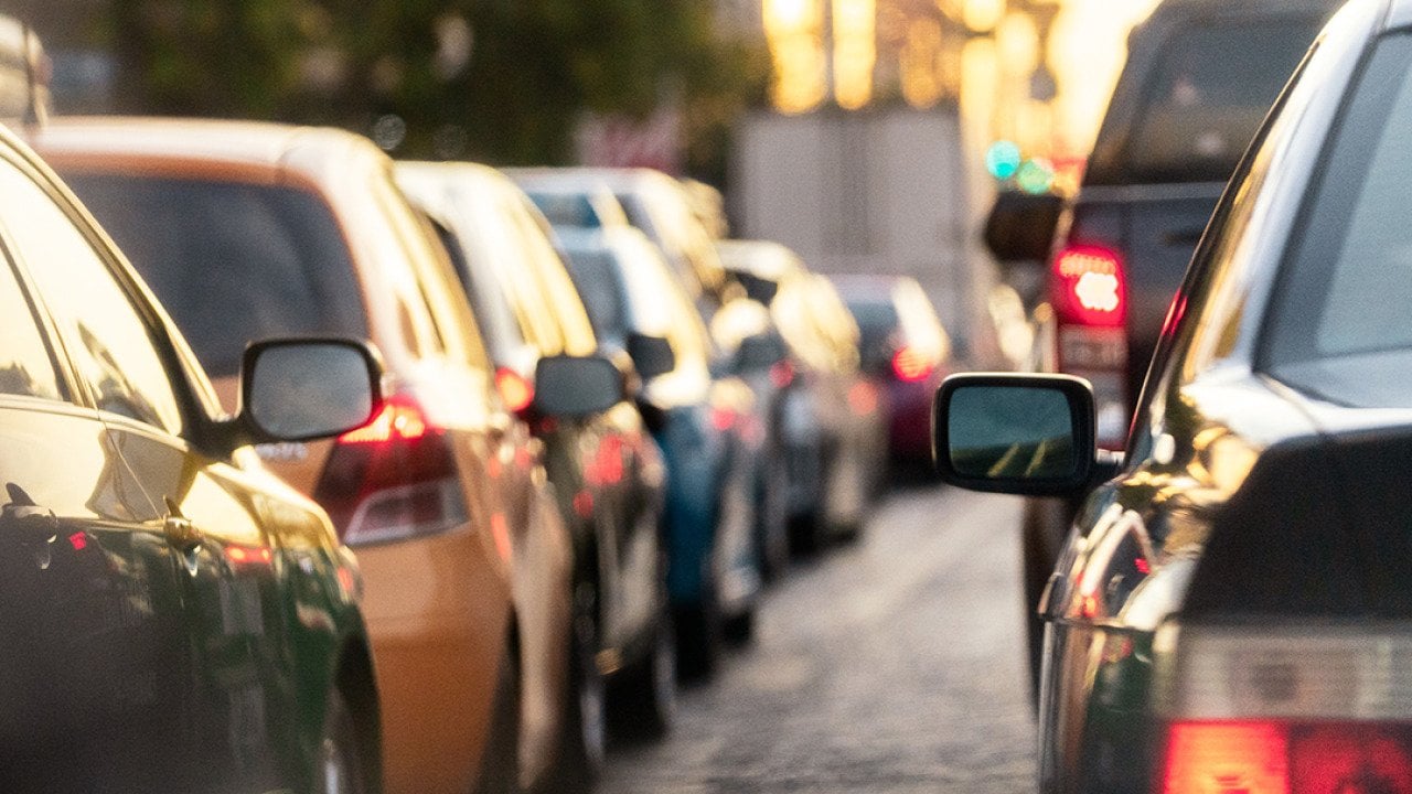 A lane of cars on the road during rush hour.