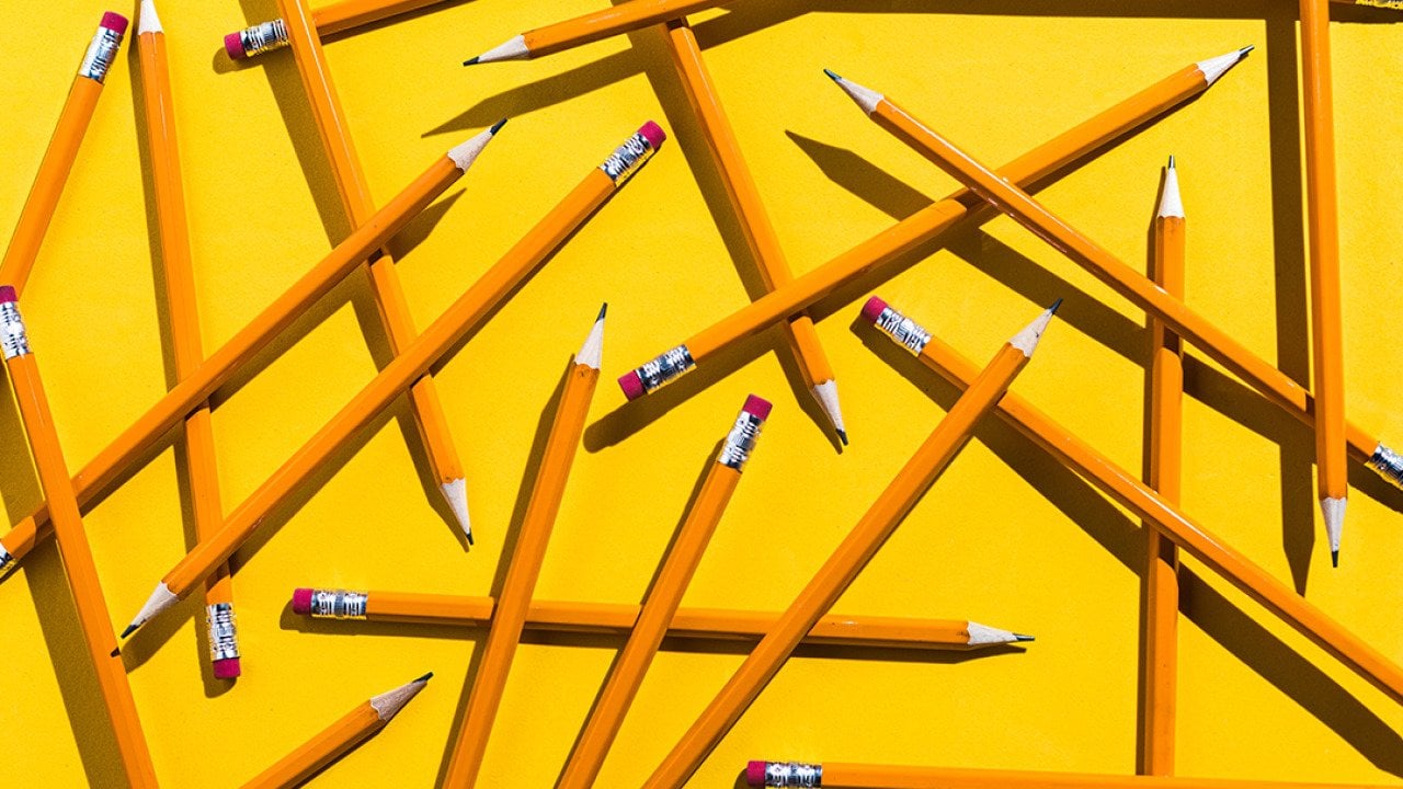 Scattered pencils on a yellow background.