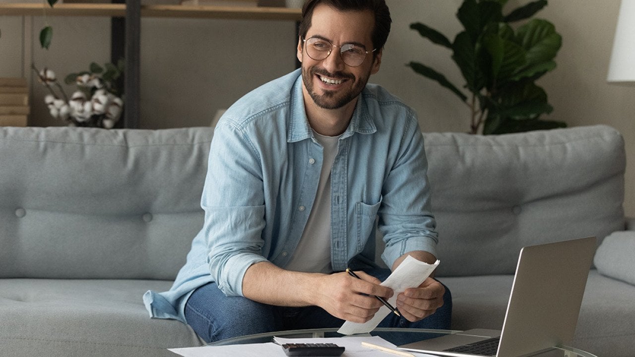 Happy man holding credit documents.