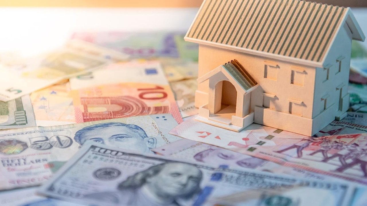 House model on various of international banknotes on the table. 