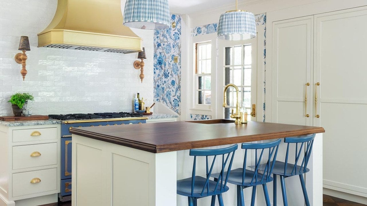 French style country kitchen with white tile, dark countertops and blue and white wallpaper accents.
