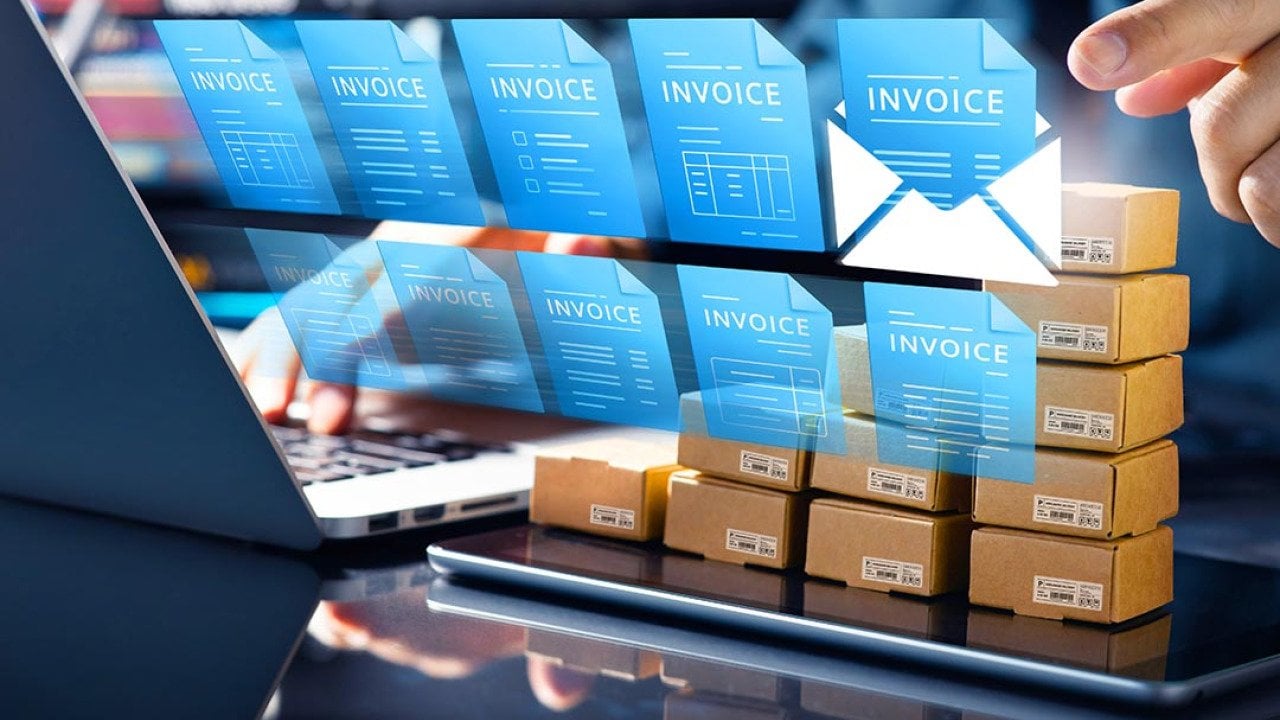 Concept of technology in accounting illustrated by 10 blue virtual invoice icons superimposed over person using a laptop computer.