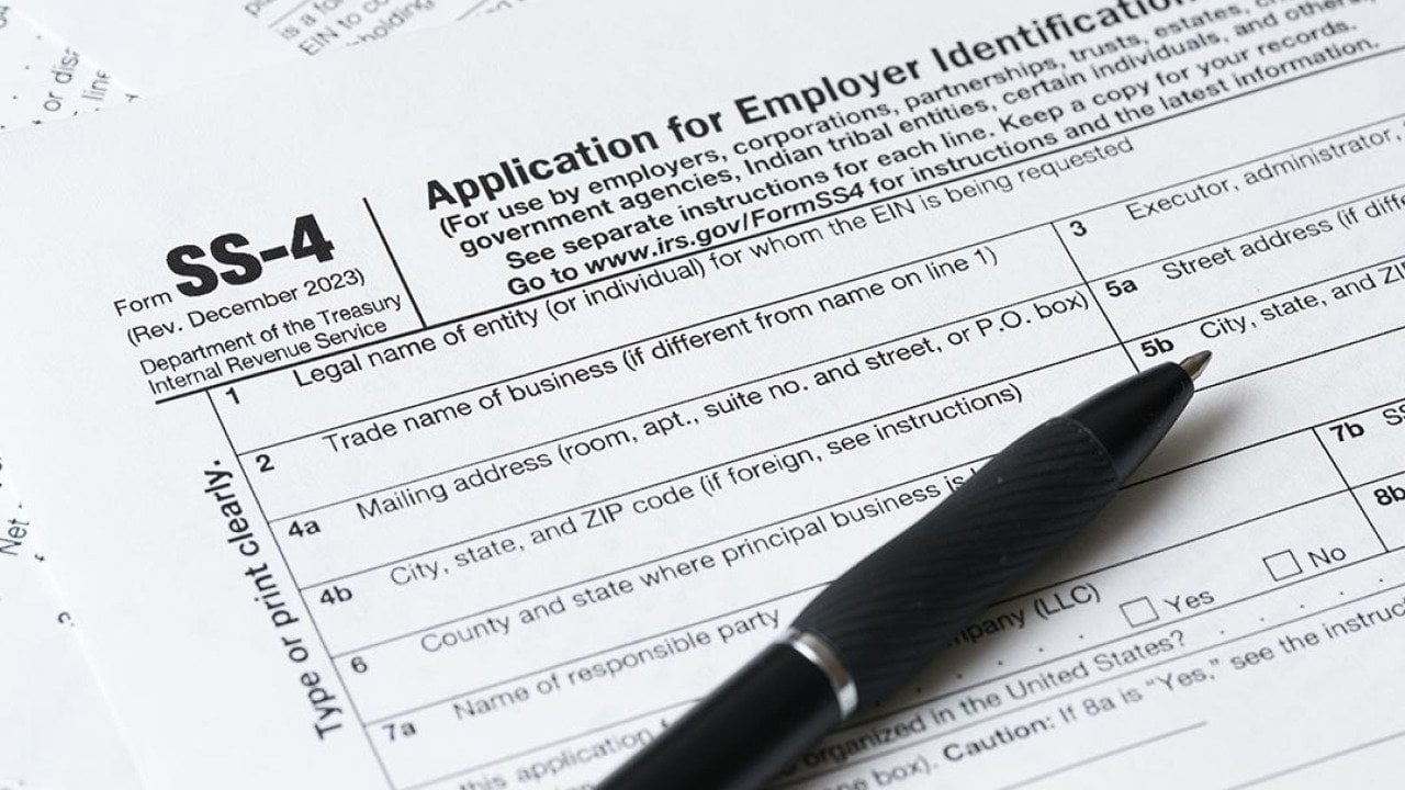Pen resting on paper application for EIN, the SS-4 form.