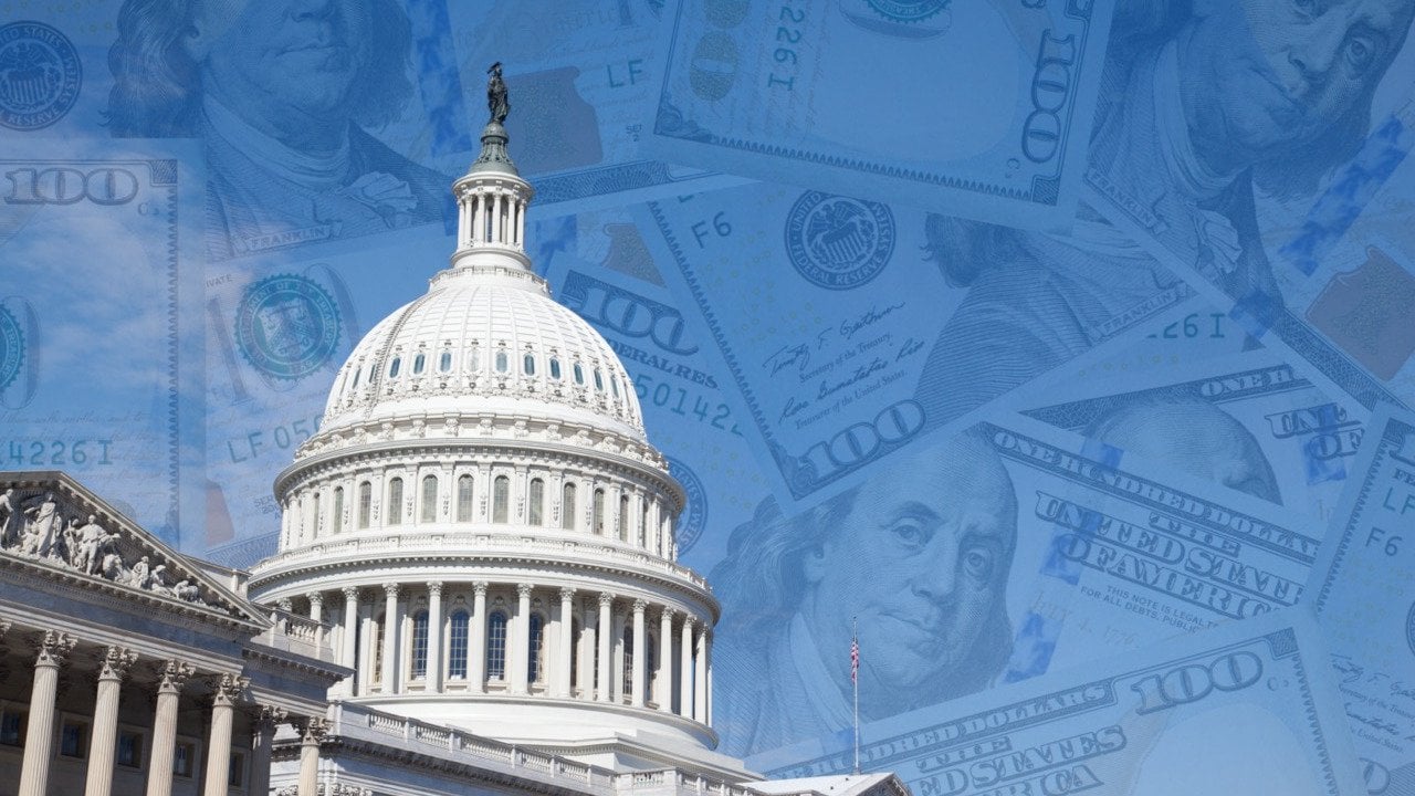 Cutout of U.S. capitol with 100 dollar banknotes layered over the blue sky.