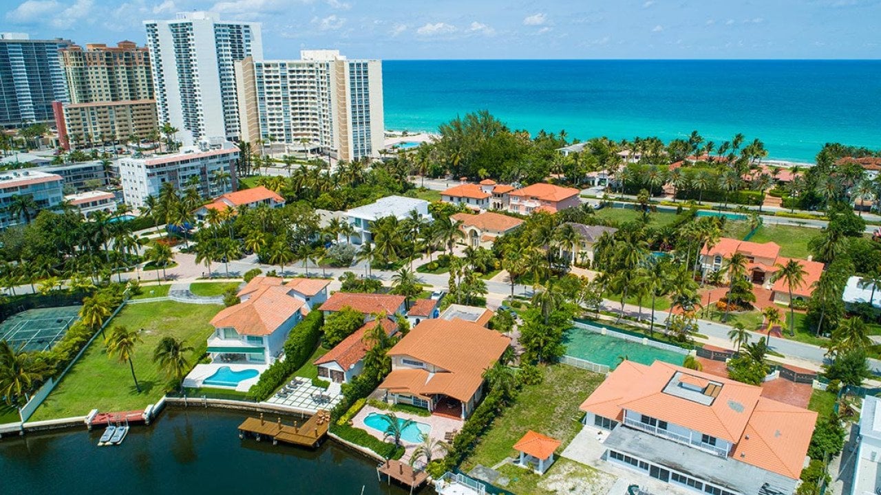 Aerial shot of luxury Miami homes with ocean in background.