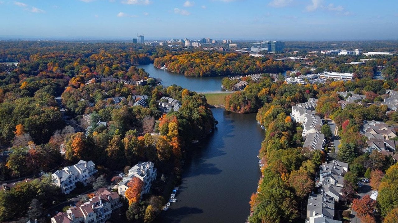 Aerial view of colorful fall trees surround lakes and homes in Fairfax County, Virginia. 