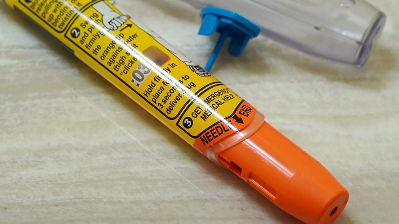 A discarded Epipen auto injector lying beside a sink.