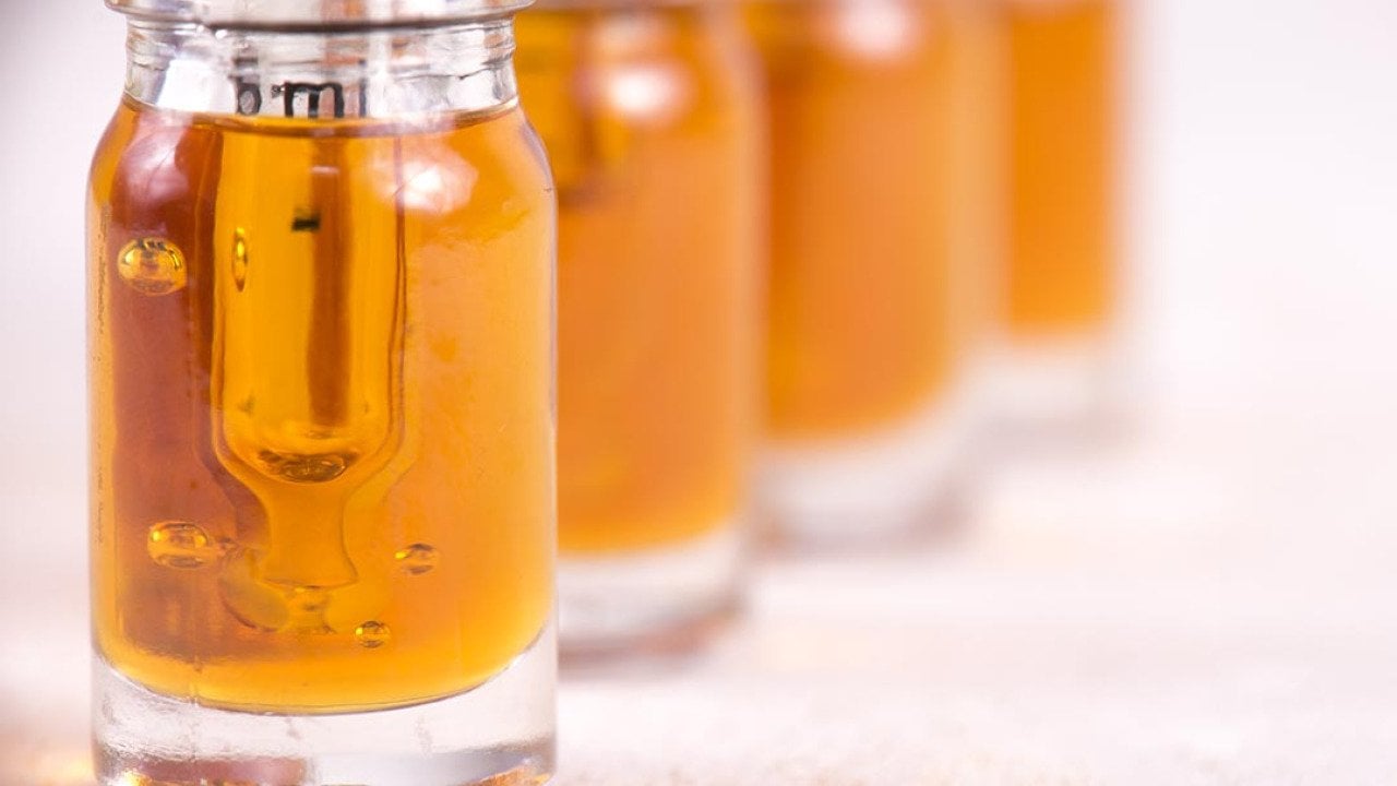 Macro detail of dropper with CBD oil, cannabis live resin extraction isolated on white background.