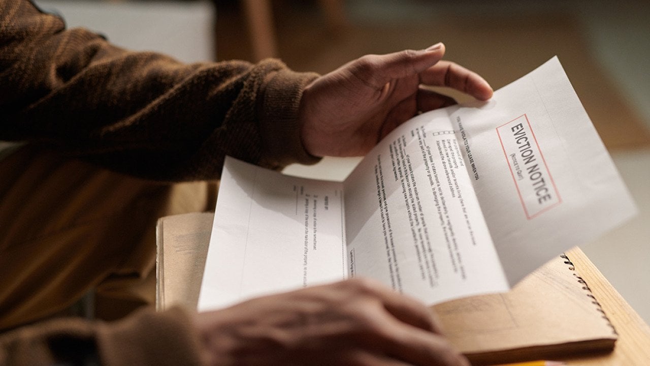 Close-up of a person reading an eviction notice letter.
