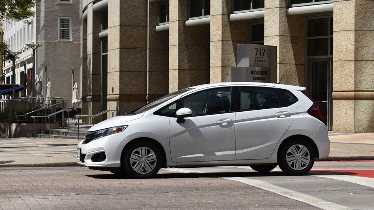 A white Honda Fit EX-L FWD car in downtown Houston, Texas.