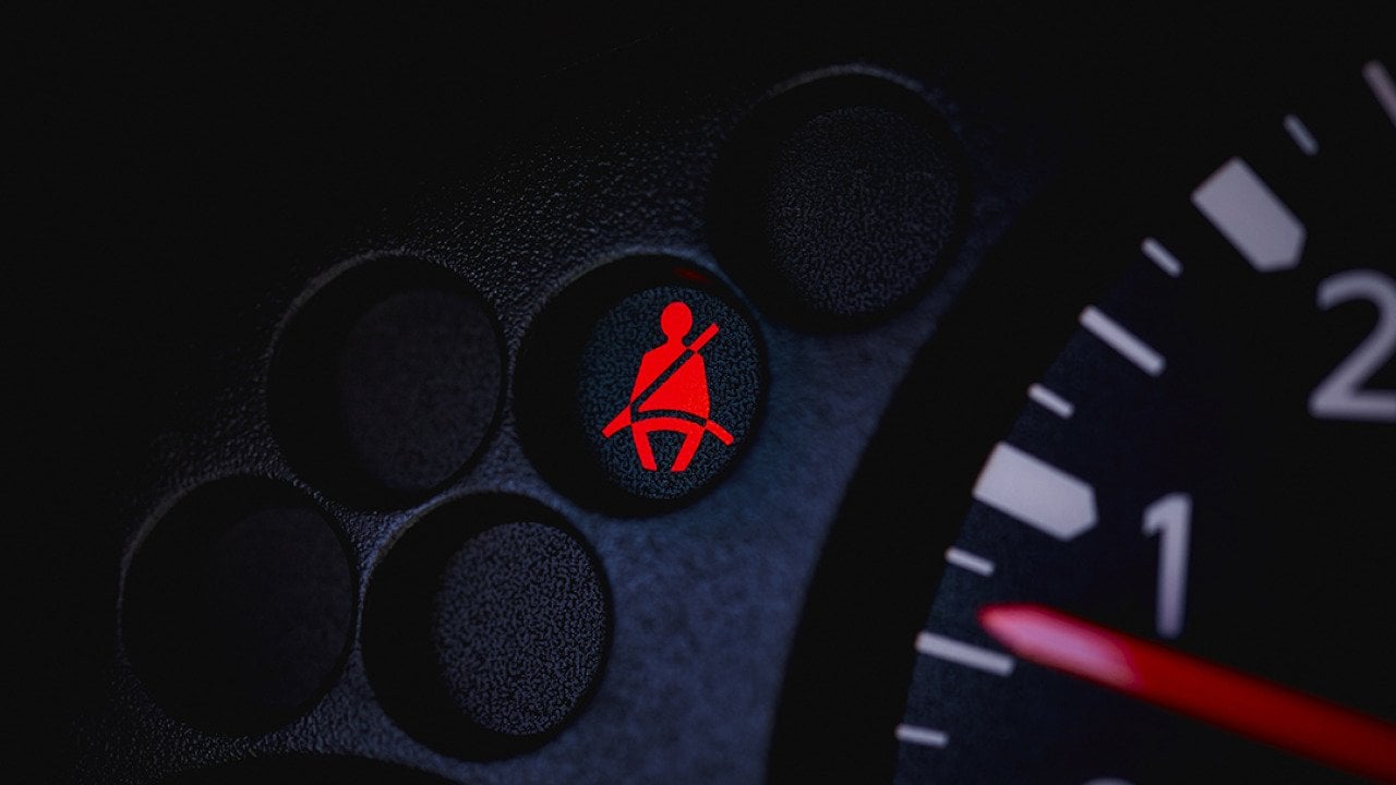 A car's dashboard with the seatbelt warning light turned on.