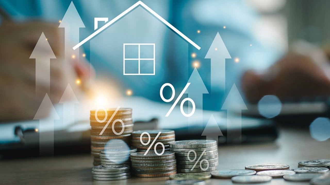 Home insurance and real estate protection concept graphics over stacks of coins.