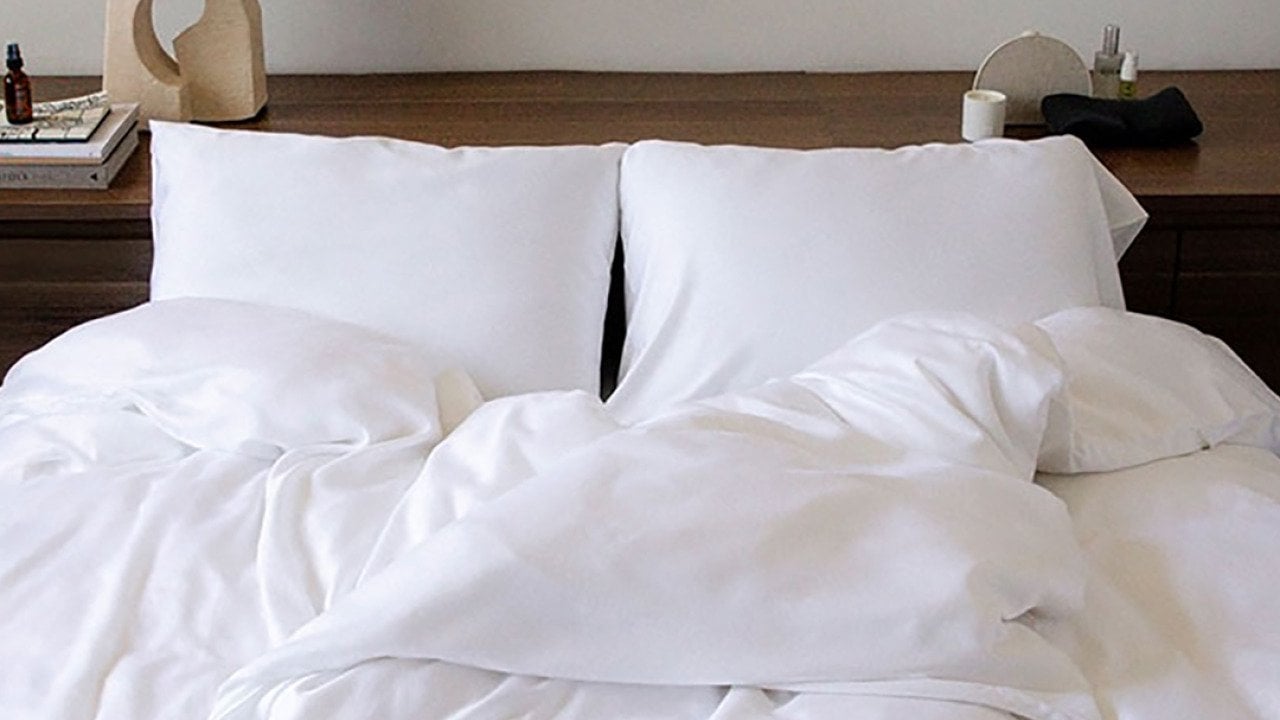 A double size bed with white sheets.