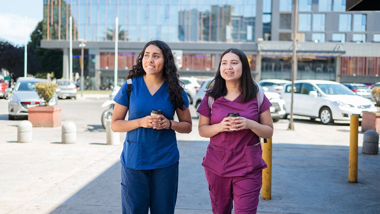 Two young female nurses having coffee after work.