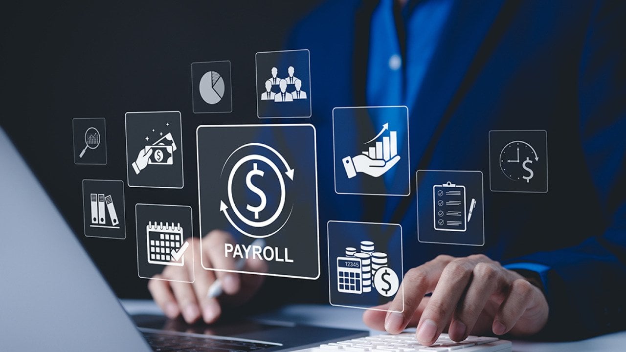 A payroll employee working on his laptop illustrated with payroll management system concept graphics.