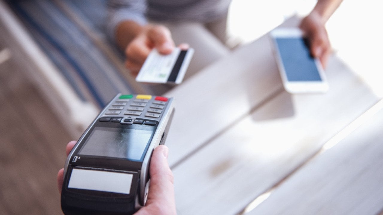 Person paying with a credit card at a cafe.