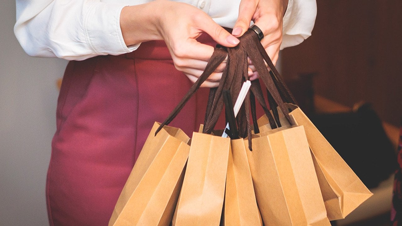 Employee holding corporate gift bag packages.