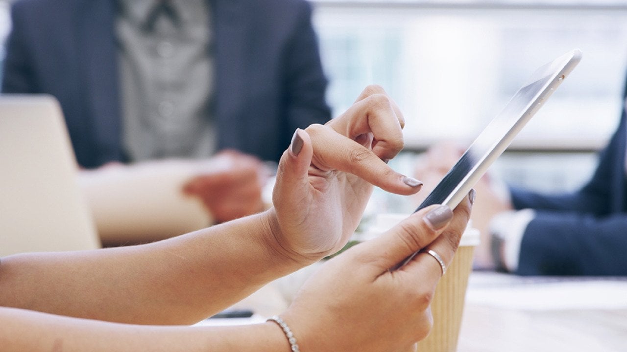 Businesswoman using a tablet during a team meeting.