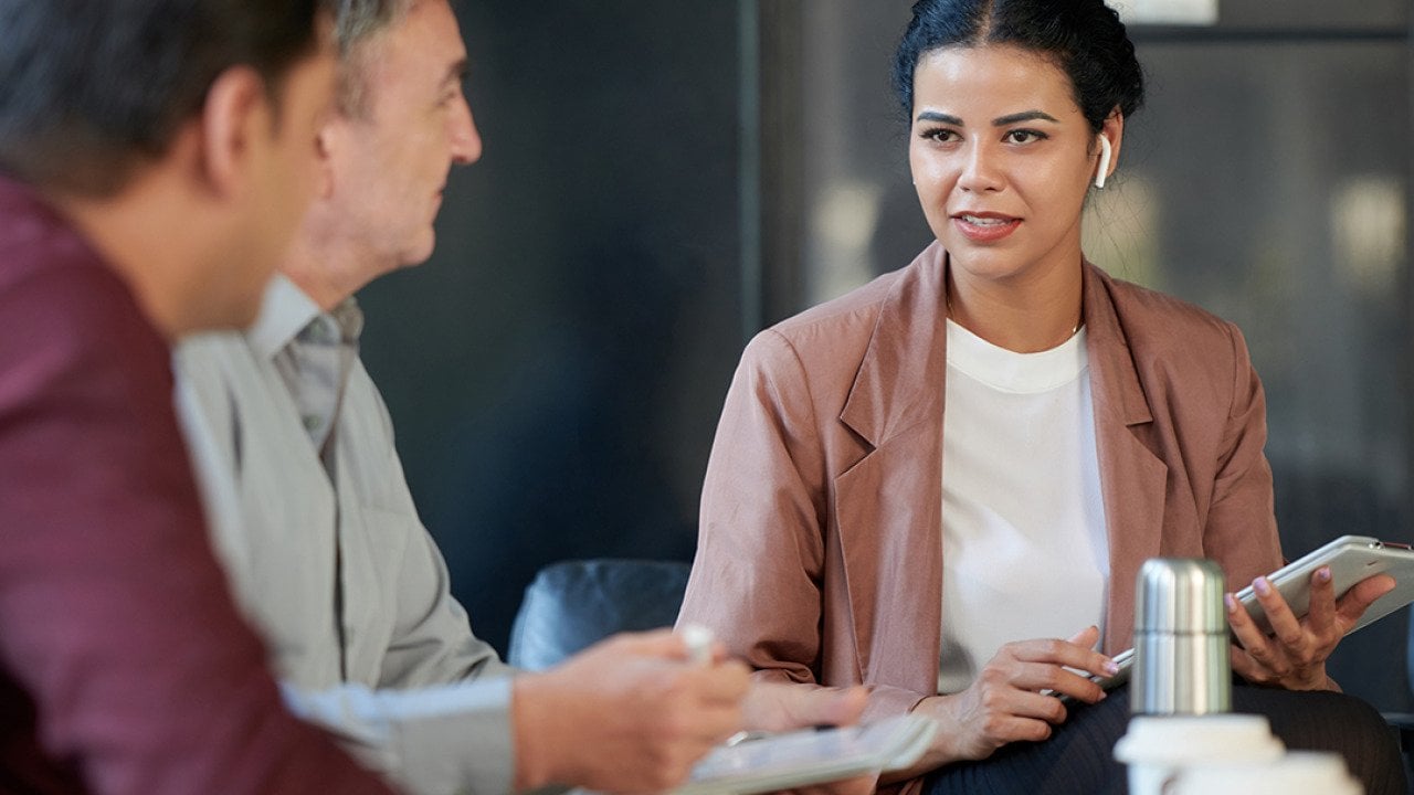A female chief marketing officer in a meeting with her colleagues.