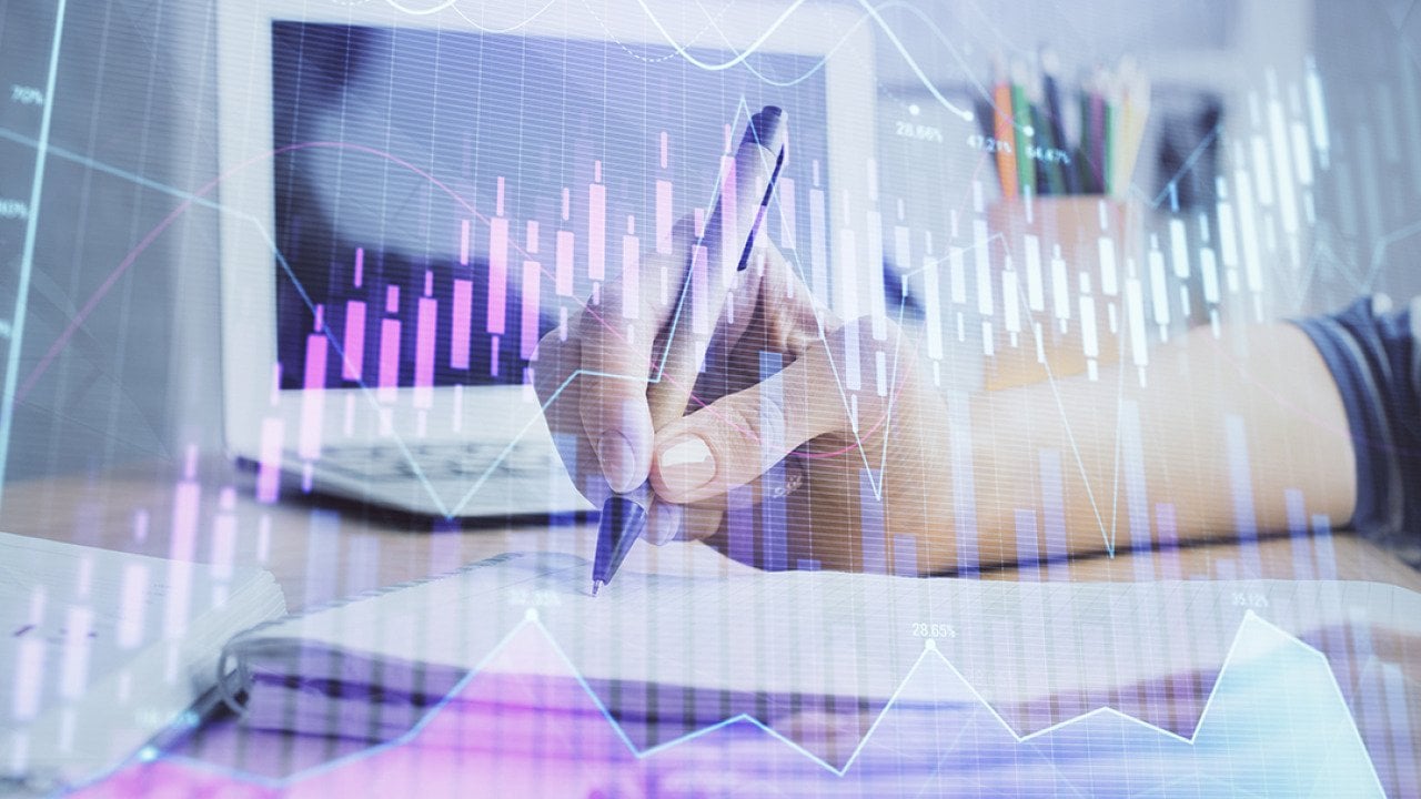 Businesswoman writing notes illustrated with finance, forex charts graphics.