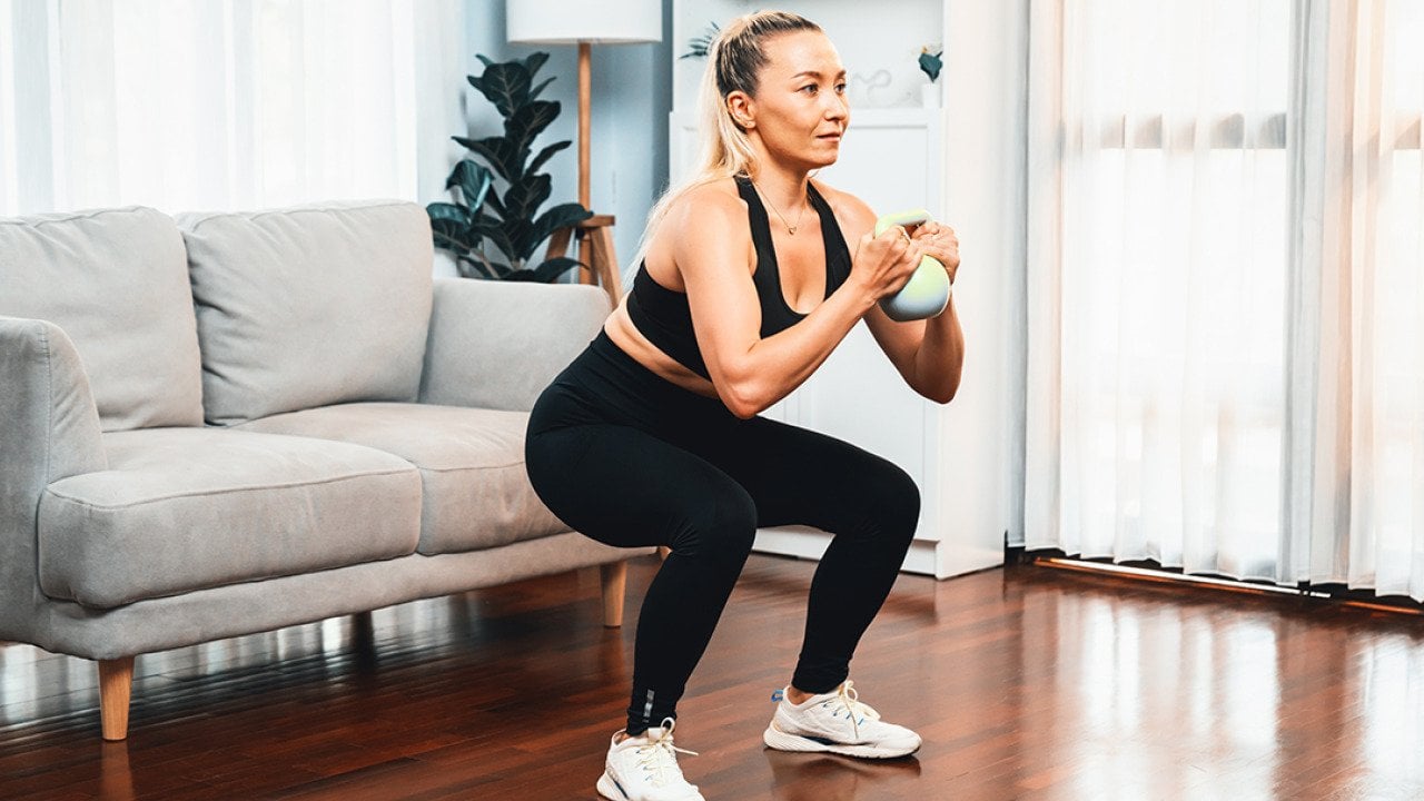 Woman at home in a leg day training session.